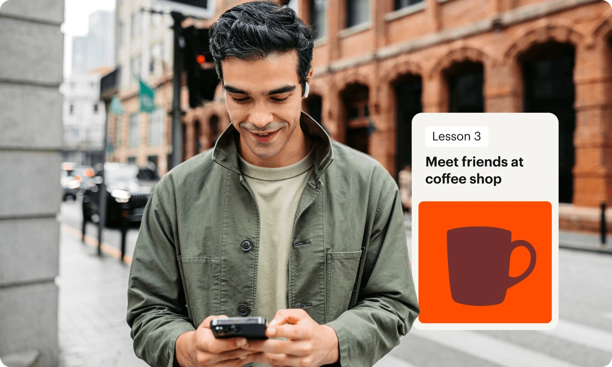Babbel language learning app displaying a lesson on 'Meet friends at coffee shop' on a smartphone, used by a smiling person in a city.
