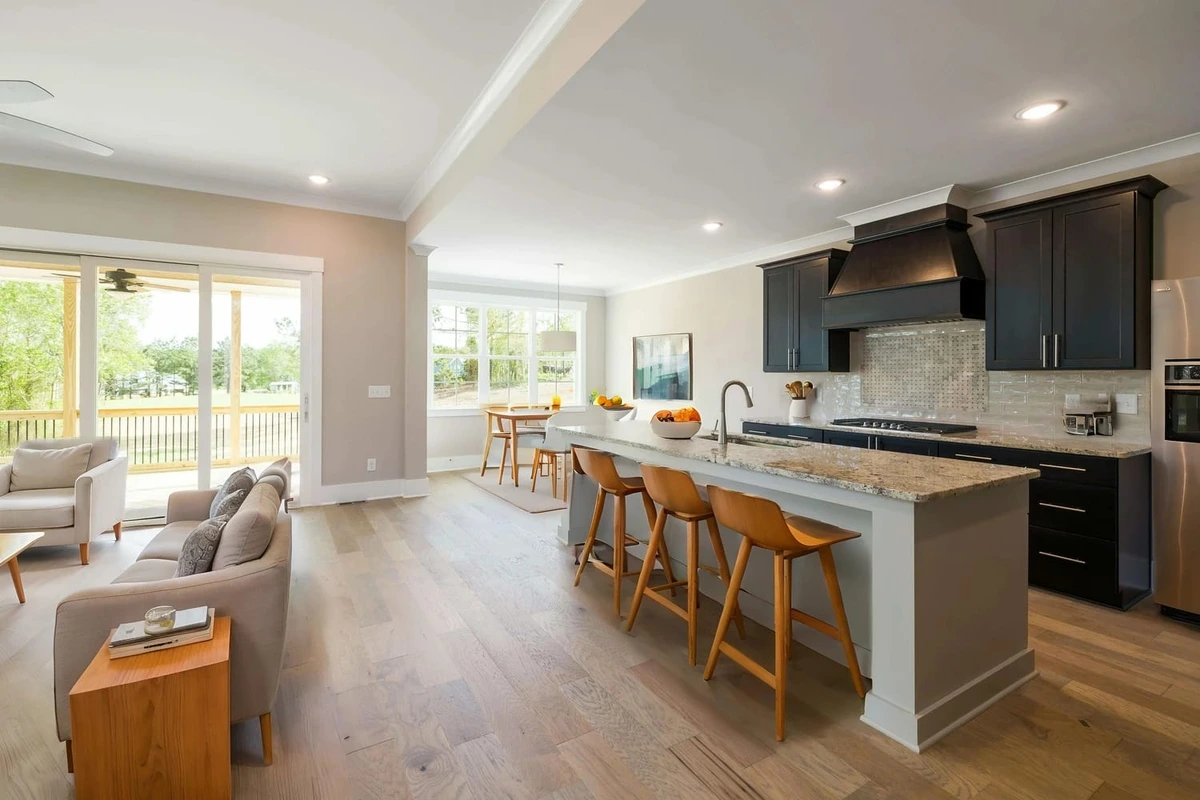 Virtual-staging-ai output sample: A professionally staged, modern open-concept living room and kitchen with light wood floors and dark cabinets.